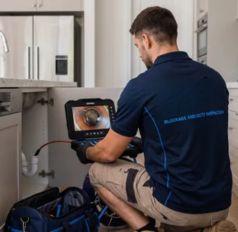 Plumber clearing a blocked toilet in a Galston bathroom